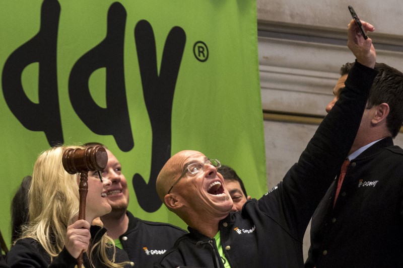 © Reuters. GoDaddy CEO Blake Irving takes "selfie" photo with a customer before they ring the opening bell to celebrate his web hosting company GoDaddy's IPO on the floor of the New York Stock Exchange