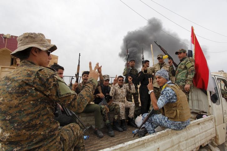 © Reuters. Paramilitares xiitas acenam num caminhão em Tikrit, no Iraque