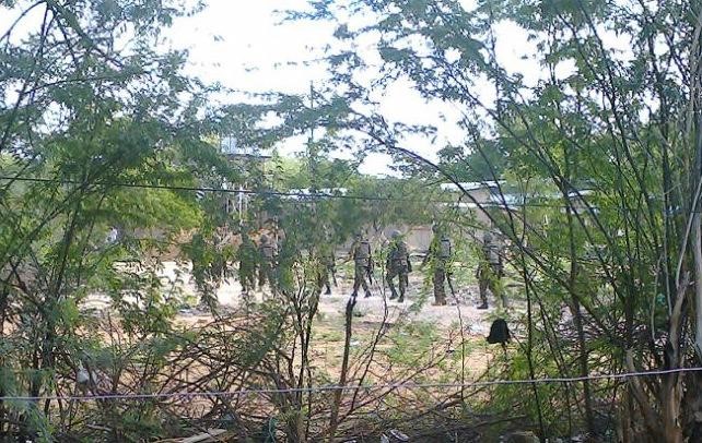 © Reuters. Kenya Defence Forces soldiers move behind a thicket in Garissa town in this photograph taken with a mobile phone