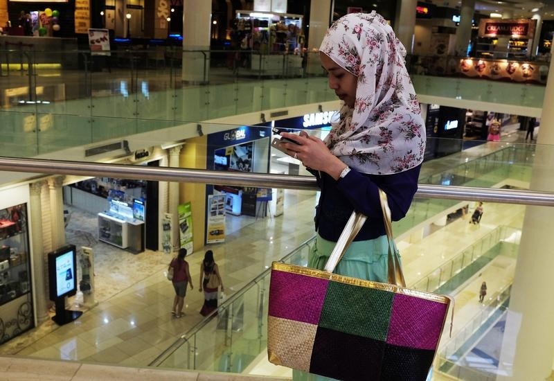 © Reuters. An Indonesian woman uses her phone at a mall in Jakarta