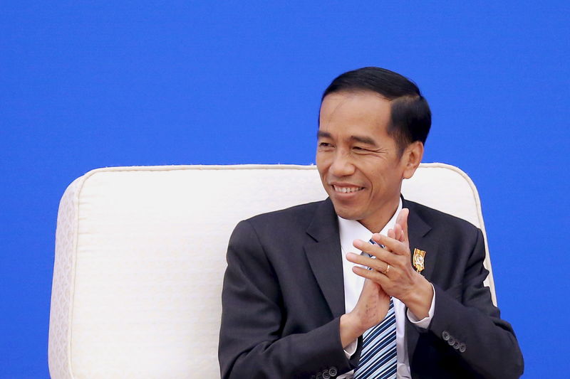 © Reuters. Widodo applauds as Li speaks during the Indonesia-China Economic Cooperation Forum at the Great Hall of the People in Beijing