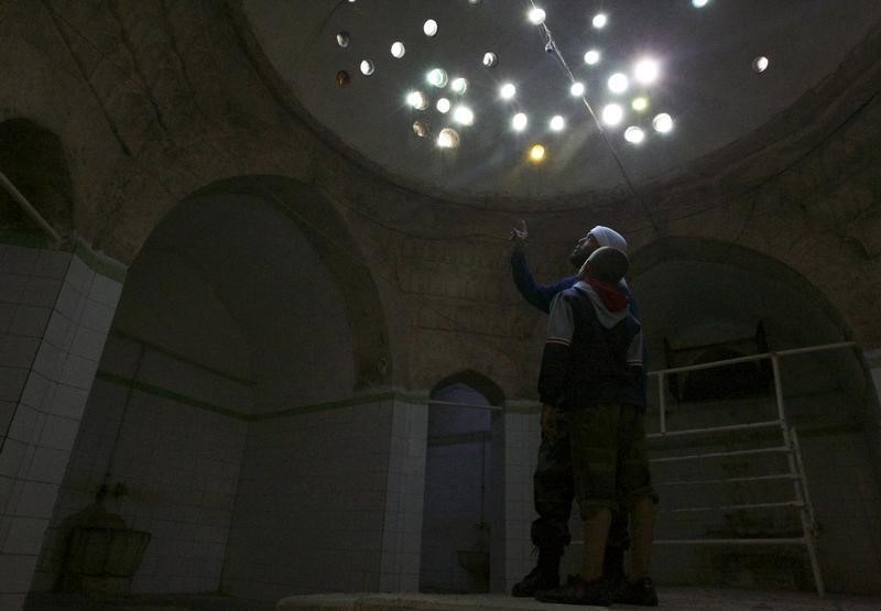 © Reuters. A Free Syrian Army fighter points at holes in the ceiling inside Maaret al-Naaman's museum, which the FSA is using as a base, in Idlib