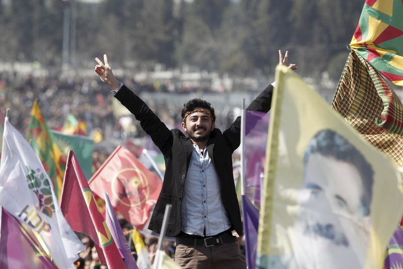 © Reuters. Kurdish man gestures while others wave Kurdish flags during a gathering celebrating Newroz, which marks the arrival of spring and the new year, in Istanbul 