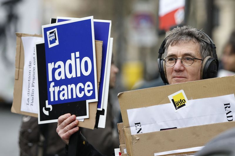 © Reuters. A striking Radio France employee holds placards during a demonstration in Paris