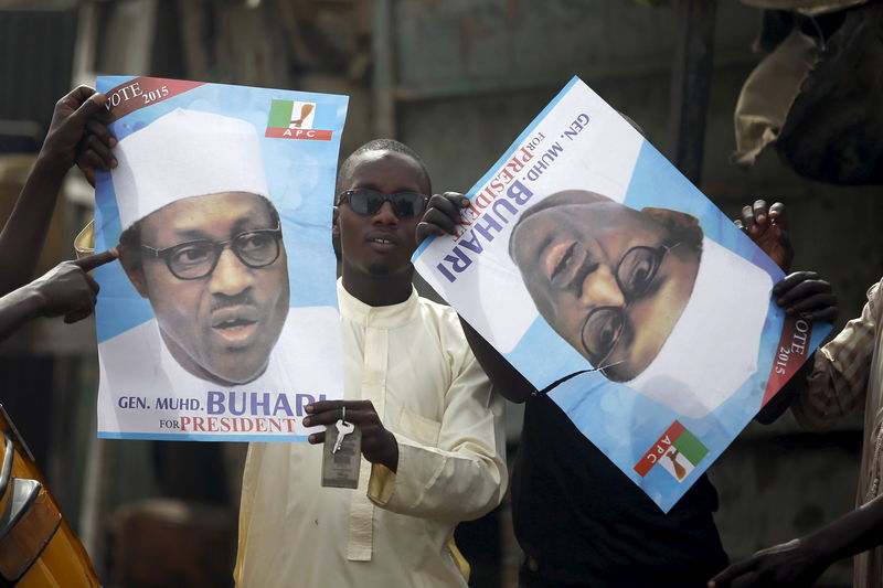 © Reuters. Supporters of presidential candidate Buhari hold his election posters in Kano 