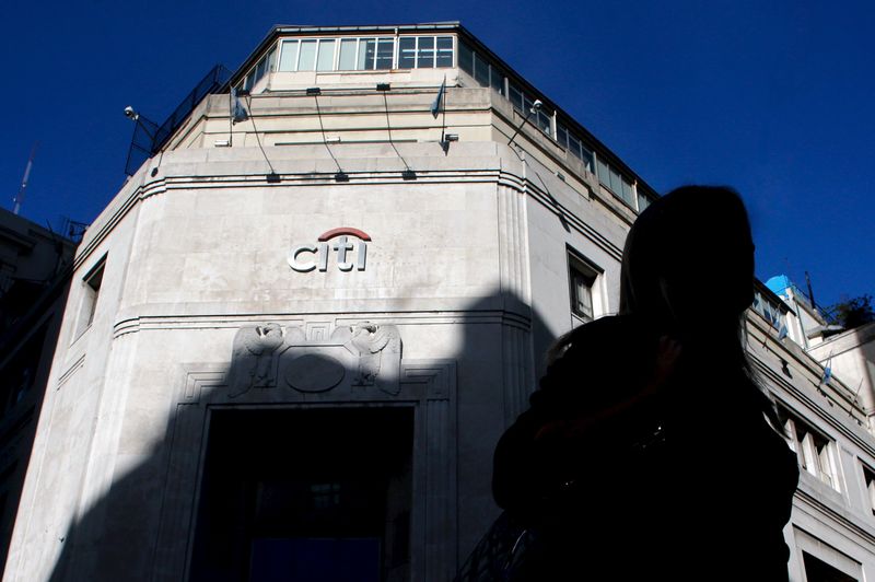 © Reuters. Woman is silhouetted as she walks past Citibank headquarters in Buenos Aires' financial district