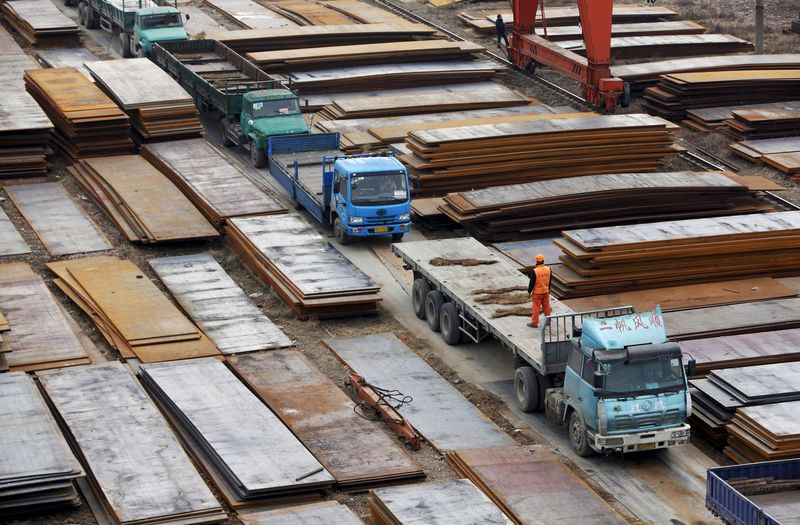 © Reuters. File picture of a labourer standing atop a lorry at a steel market in Wuxi