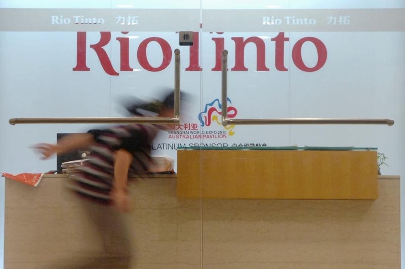 © Reuters. A woman runs past the reception desk of the Rio Tinto Limited Shanghai Representative Office in Shanghai