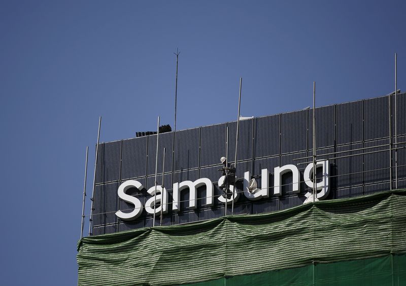 © Reuters. A worker works on a Samsung outdoor advertisement installed atop an office building in central Seoul