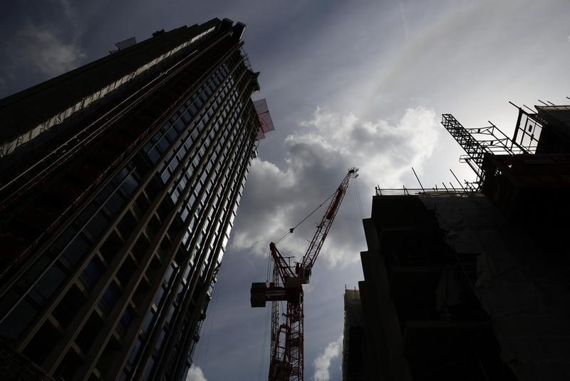 © Reuters. A crane is silhouetted at a construction site in central London