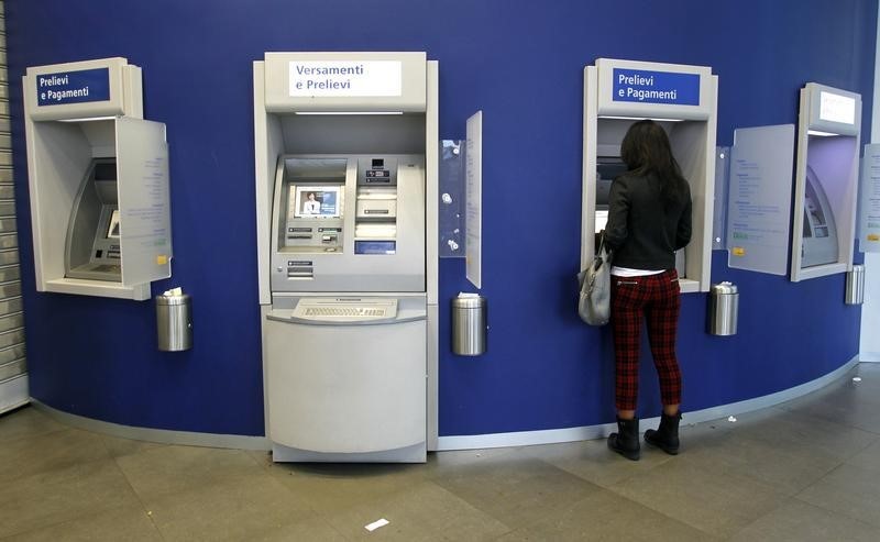 © Reuters. A woman gets money at an ATM machine in Milan