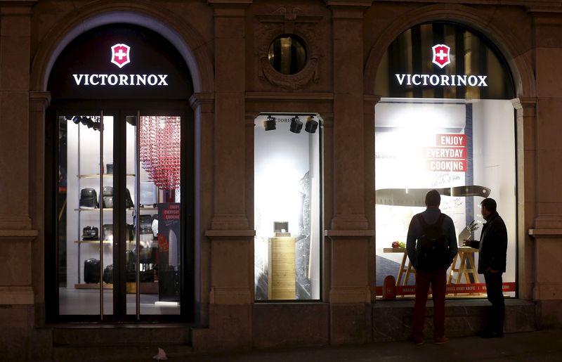 © Reuters. People stand in front of a display window of a shop of Swiss knife manufacturer Victorinox in Zurich
