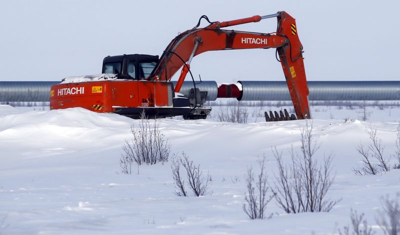 © Reuters. Excavator is seen next to oil pipeline at Suzunskoye oil field north from Krasnoyarsk