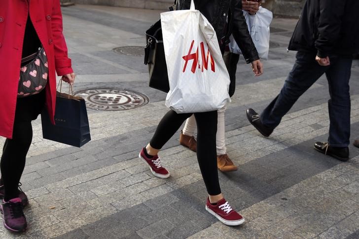 © Reuters. Women with Zara and H&M shopping bags walk at a shopping district in central Madrid