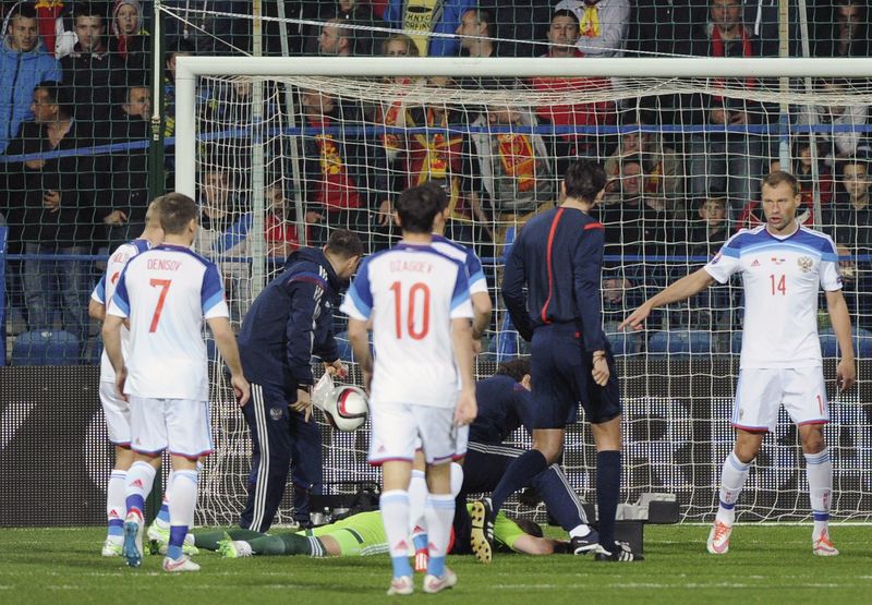 © Reuters. Russia's goalkeeper Akinfeev lies on the ground during the Euro 2016 Group G qualifying soccer match against Montenegro in Podgorica