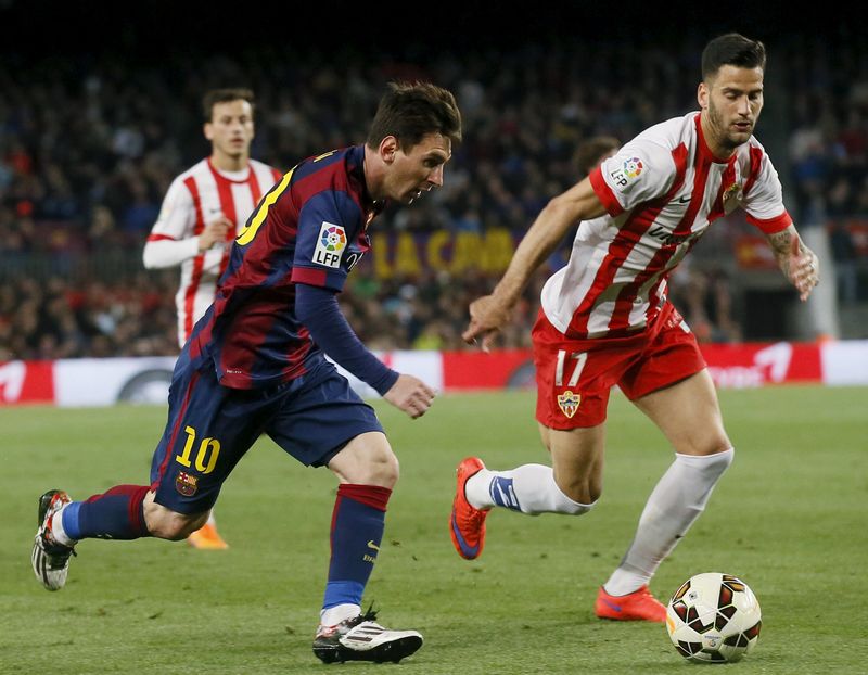 © Reuters. Barcelona's Lionel Messi vies the ball against Almeria's Edgar Mendez during their Spanish first division soccer match at Camp Nou stadium in Barcelona