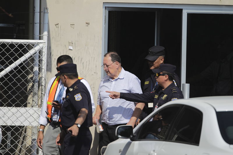 © Reuters. Carlos Eugenio Vides Casanova, former Salvadorean minister of defense from 1983-1989, is escorted by policemen upon his arrival at El Salvador International Airport 