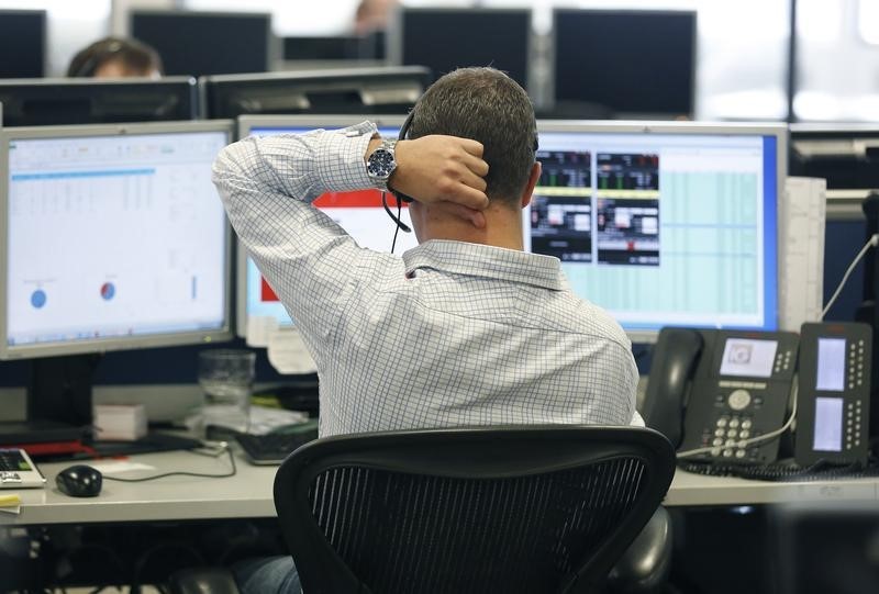 © Reuters. A trader sits at his desk at IG Index in London