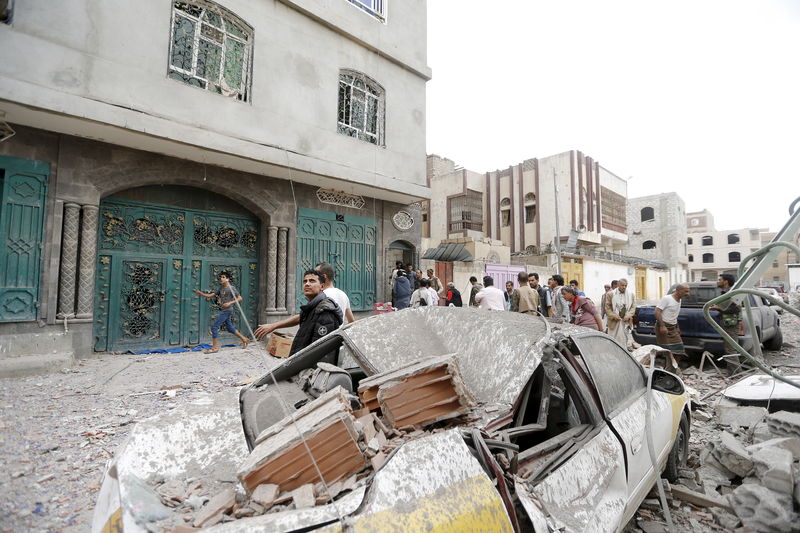 © Reuters. Pessoas em local de ataque aéreo em Sanaa