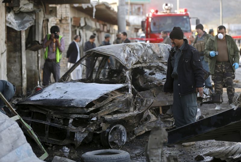 © Reuters. Policiais do Afeganistão examinam local do ataque suicida com carro-bomba em Cabul