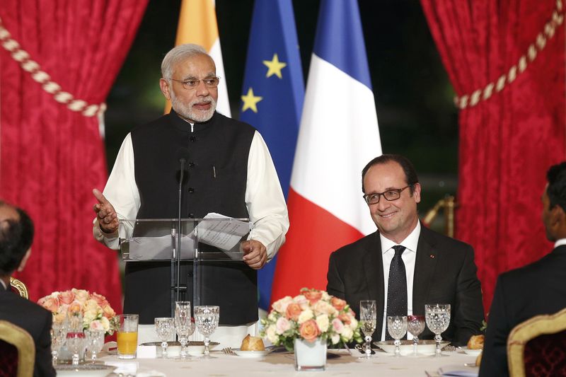 © Reuters. French president Francois Hollande listens to the speech of Indian prime minister Narendra Modi during an official dinner in his honor at the Elysee Palace in Paris, France, 10 April 2015.