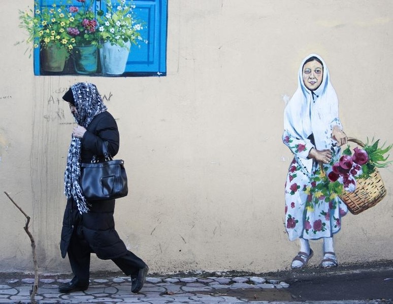 © Reuters. A woman walks on a sidewalk in central of Tehran