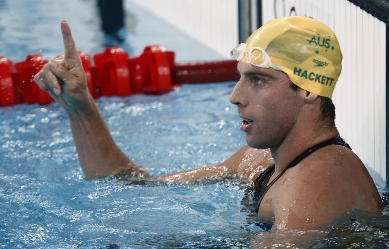© Reuters. Grant Hackett of Australia gestures after setting an Olympic record and winning his men's 1500m freestyle swimming heat at the National Aquatics Center during the 2008 Beijing Olympics