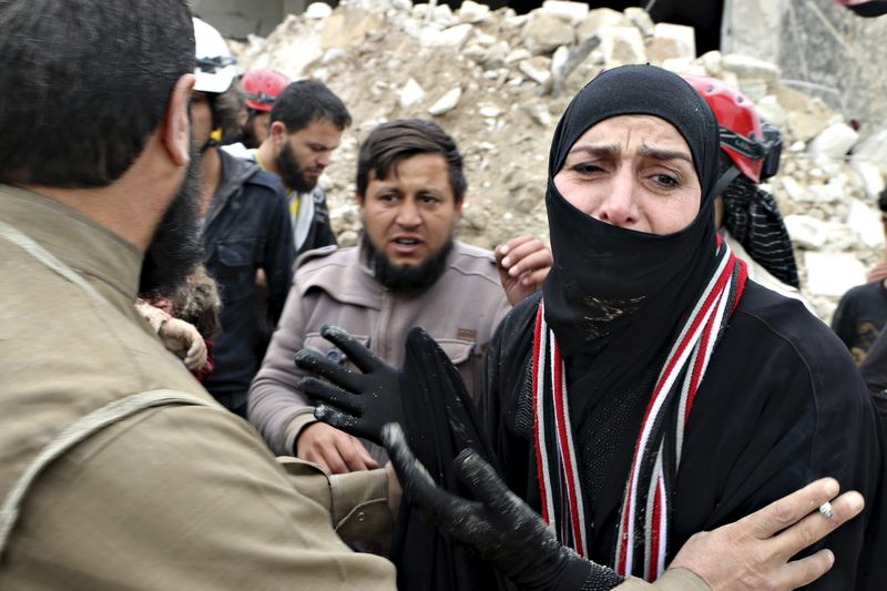 © Reuters. A woman reacts while civil defence members carry her dead child after what activists said was shelling by warplanes loyal to Syria's president Bashar Al-Assad in Aleppo's rebel-controlled Bab Al-Nairab district