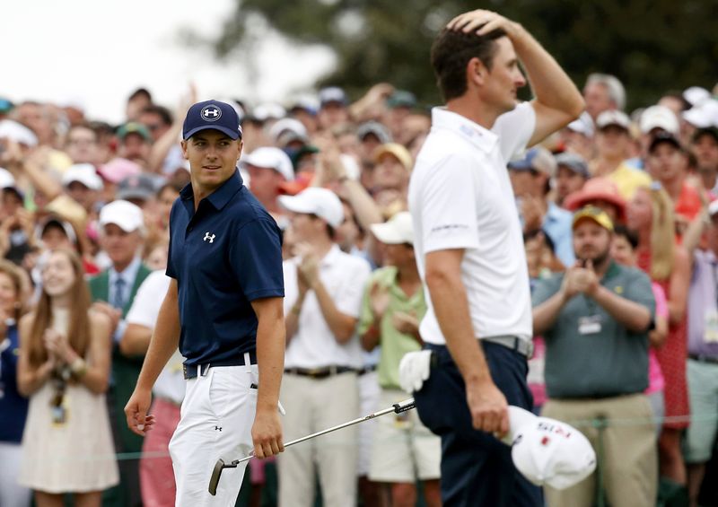 © Reuters. Spieth of the U.S. walks past Rose of Britain after winning the Masters during final round play of the Masters golf tournament at the Augusta National Golf Course in Augusta