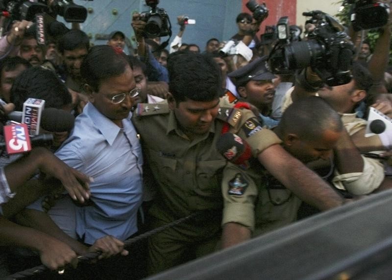 © Reuters. Policemen escort Satyam founder Raju after he was released from a jail in Hyderabad