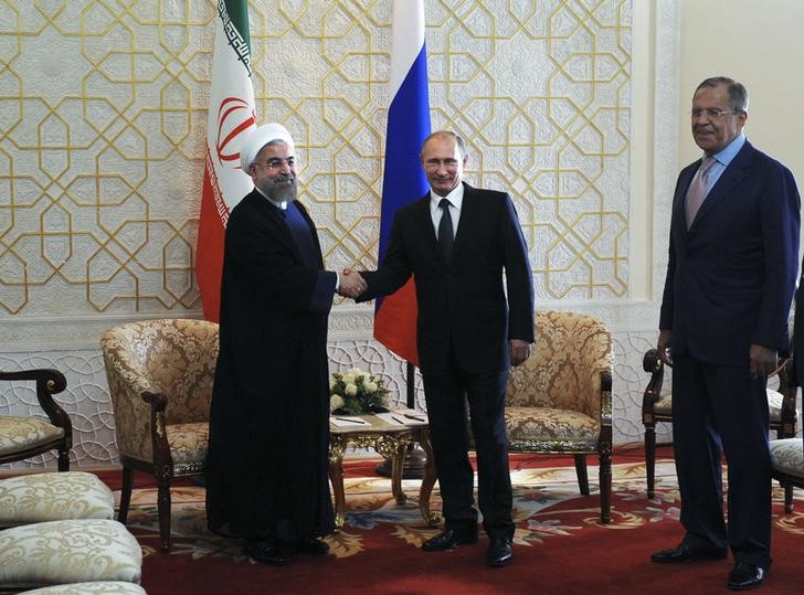 © Reuters. Iran's President Rouhani, Russia's President Putin and Russia's FM Lavrov pose for a picture before their meeting at the SCO summit in Dushanbe