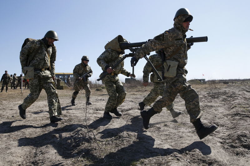 © Reuters. Newly mobilized Ukrainian paratroopers carry an anti-tank grenade launcher during a military drill near Zhytomyr