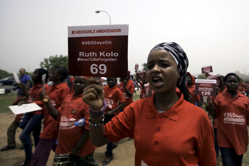 © Reuters. A girl holds a sign during a march to mark the one-year anniversary of the mass kidnapping of more than 200 schoolgirls from a secondary school in Chibok by Boko Haram militants, in Abuja