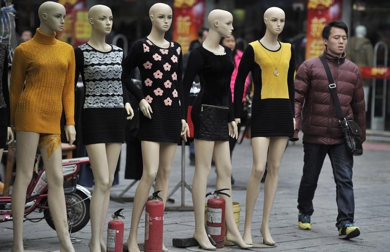 © Reuters. A man walks past mannequins at a wholesale market in Hefei