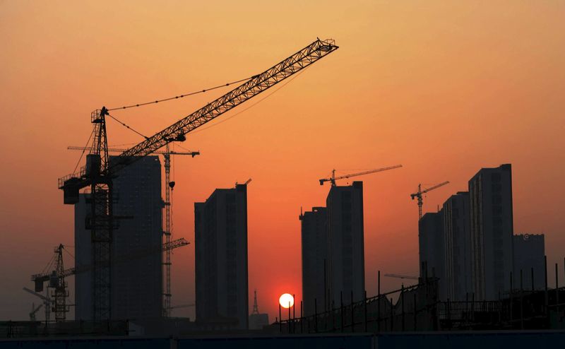 © Reuters. The sun sets behind a residential construction site in Rizhao