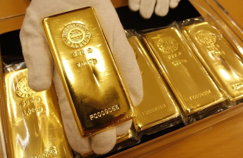 © Reuters. Сотрудник Tanaka Kikinzoku Jewelry K.K. демонстрирует слиток золота на складе компании в Токио