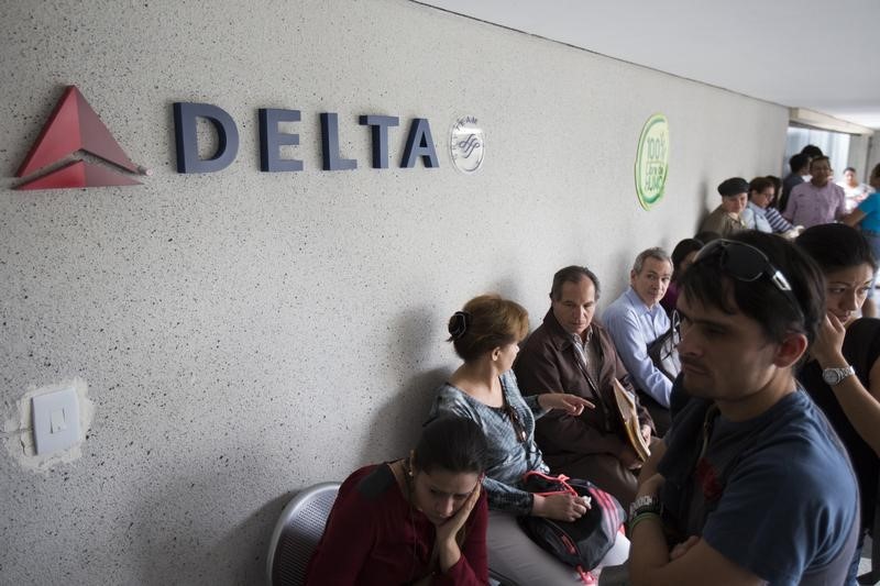 © Reuters. Customers wait their turn to be served in a line at the Delta airlines office in Caracas