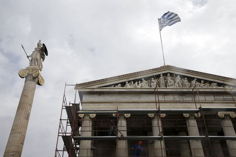 © Reuters. Workers remove scaffolding from the Athens Academy building next to a statue of Goddess Athena