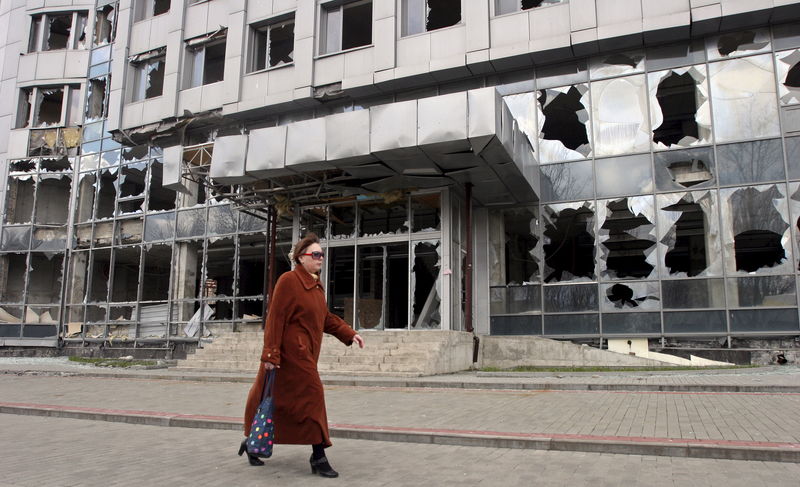 © Reuters. A woman walks past a building damaged by fighting in Donetsk