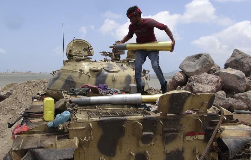 © Reuters. Militant loyal to Yemen's President Abd-Rabbu Mansour Hadi prepares a shell for a tank in the country's southern port city of Aden