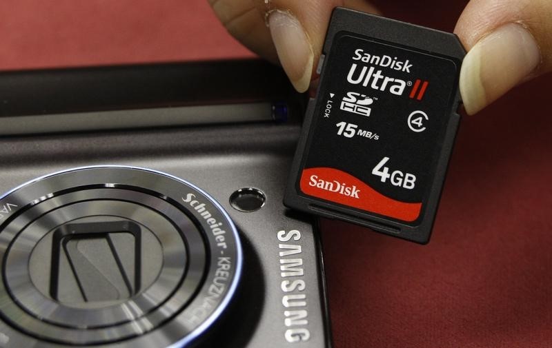 © Reuters. A shopper poses with a SanDisk memory card beside a Samsung camera in Hong Kong