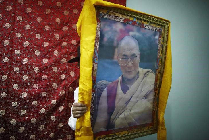 © Reuters. A Tibetan man carries a portrait of exiled Tibetan spiritual leader, the Dalai Lama, during the function organised to mark "Losar" or the Tibetan New Year at a Tibetan Refugee Camp in Lalitpur