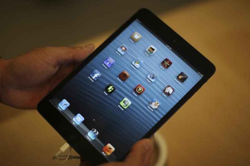 © Reuters. A man holds an iPad mini during the launch of the iPad mini and iPad with Retina display Wi-Fi models in Los Angeles