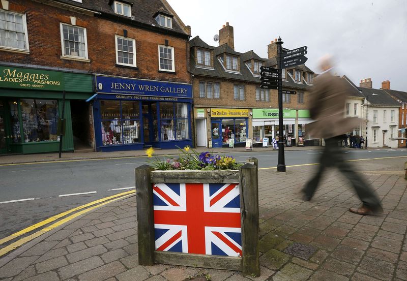 © Reuters. A man walks past a planter decorated with the union flag in Coleshill