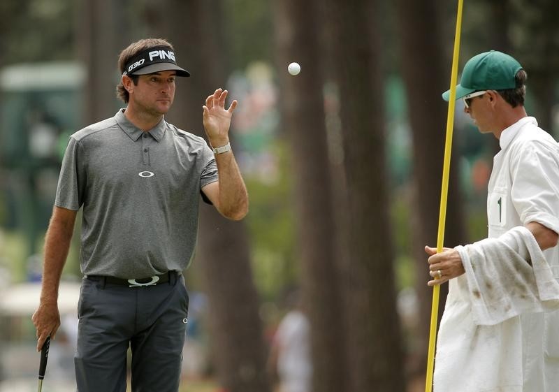 © Reuters. Bubba Watson of the U.S. gets his ball back from his caddie on the third green during third round play of the Masters golf tournament at the Augusta National Golf Course in Augusta