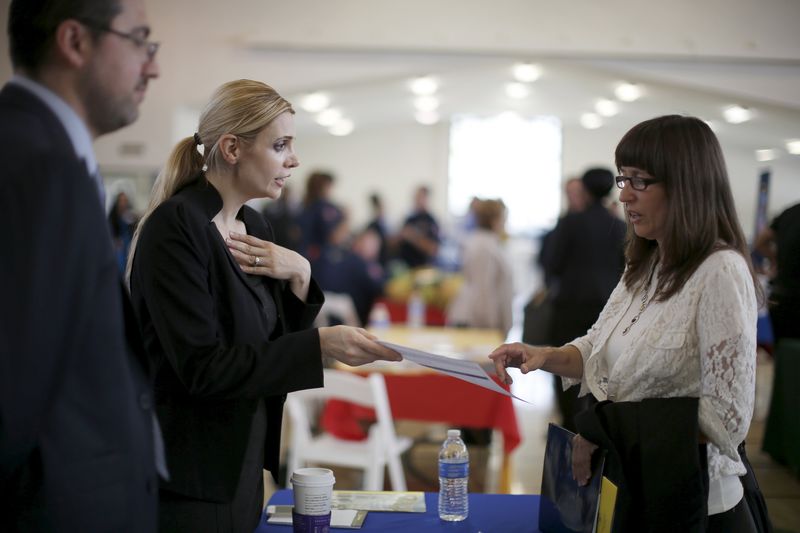 © Reuters. Job seekers browse tables at a veterans' job fair in Burbank, Los Angeles