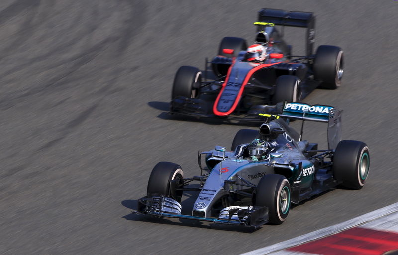 © Reuters. Mercedes F1 driver Rosberg of Germany drives in front of McLaren F1 driver Jenson Button of Britain during the Chinese F1 Grand Prix at the Shanghai International Circuit