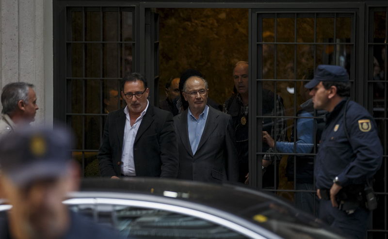 © Reuters. Rato, former People's Party minister and former managing director of the International Monetary Fund, is lead by police as they leave his residence after an inspection in Madrid