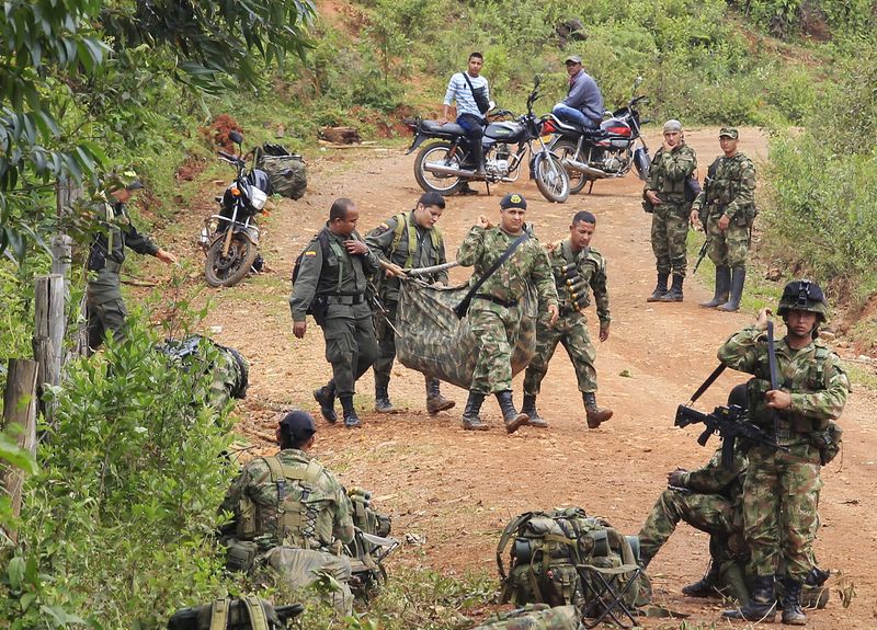 © Reuters. Soldados colombianos carregam o corpo de um colega morto após ataque rebelde