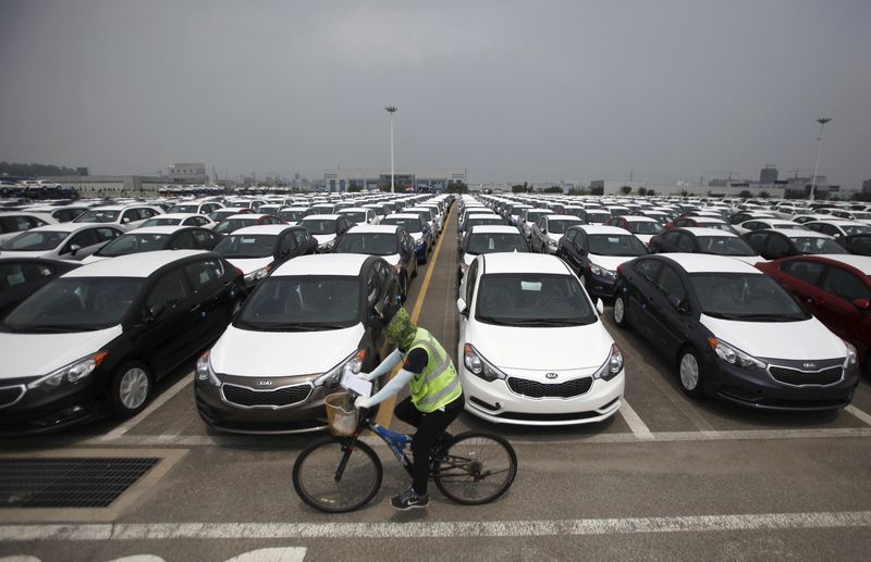 © Reuters. File photo of a worker cycling past cars made by Hyundai and Kia at the company's shipping yard in Pyeongtaek